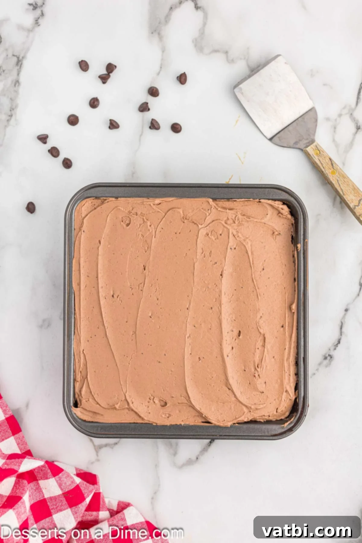 Crazy Simple Cake 12 Smooth chocolate frosting being spread evenly over the cooled crazy cake.