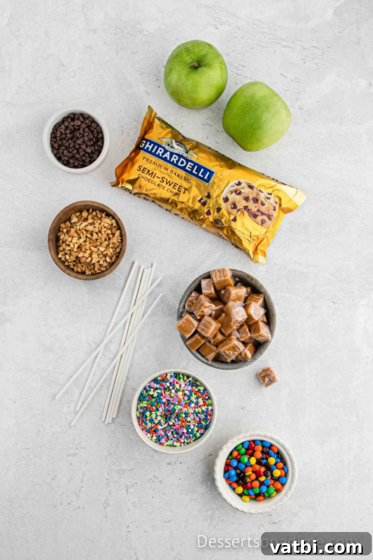 Ingredients for the best caramel apple slices - chocolate chips, caramel, granny smith apples and bowls of toppings. 