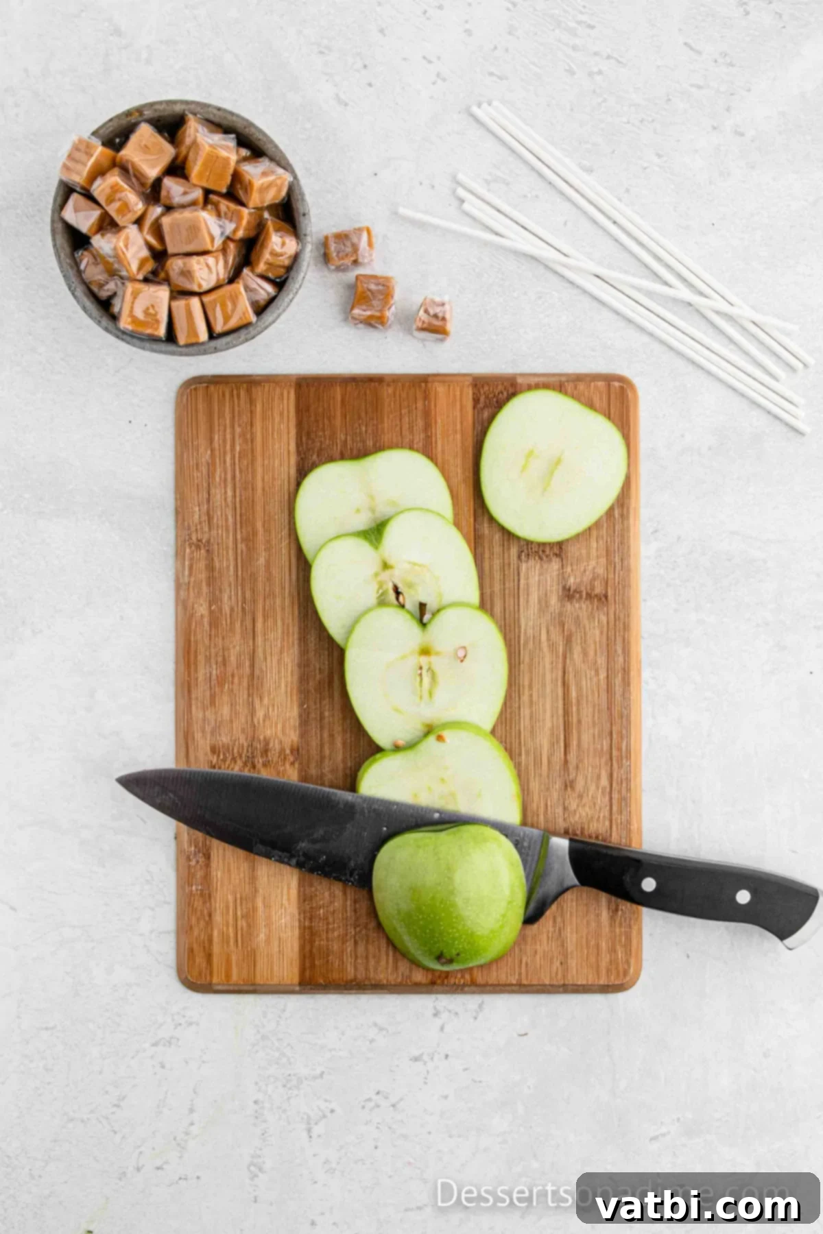 Apple on cutting board being sliced. 