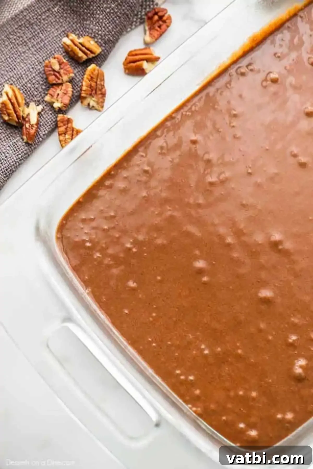 Pecan Pie Brownie Bliss 3 Brownie batter evenly spread in a baking dish, ready for its initial bake.