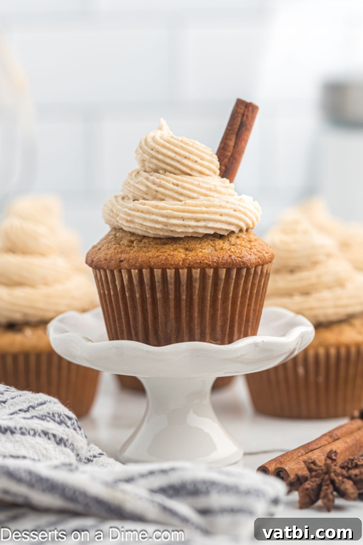Irresistible Cinnamon Cream Cheese Frosting 2 A beautifully frosted cupcake with rich cinnamon cream cheese frosting, elegantly placed on a dessert stand, showcasing its creamy texture.