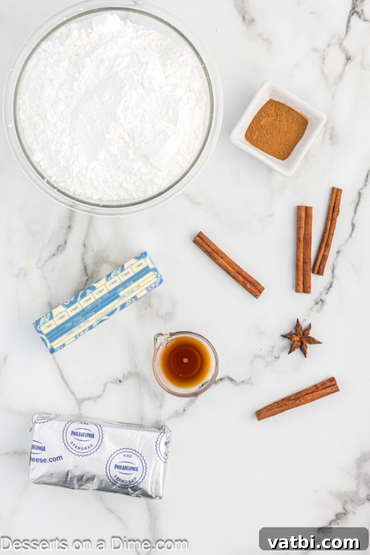Irresistible Cinnamon Cream Cheese Frosting 3 A beautiful flat lay of essential ingredients for making cinnamon cream cheese frosting, including powdered sugar, ground cinnamon, softened butter, cream cheese, and vanilla extract.