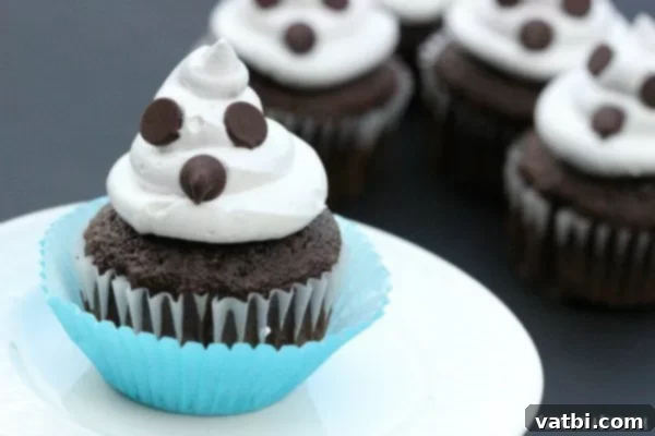 Chocolate cupcakes with frosting and ghost eyes.