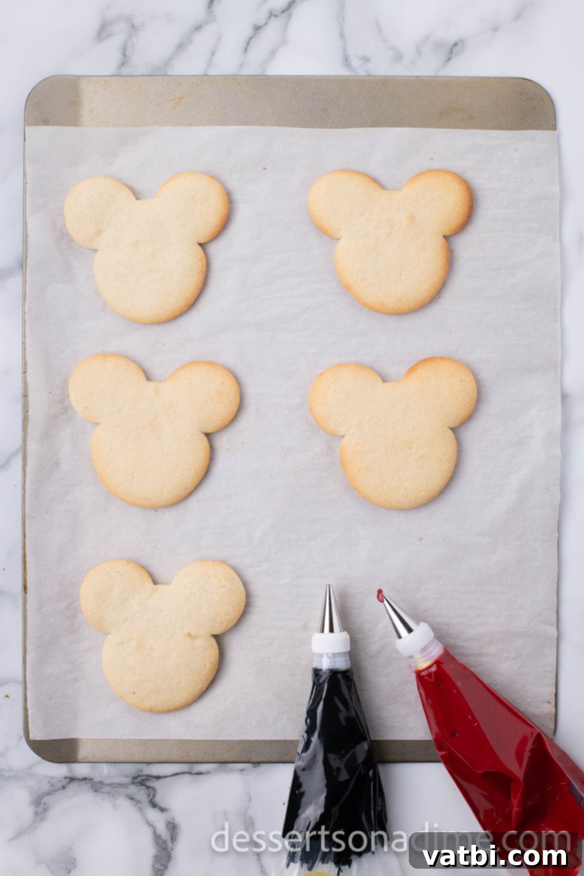 Magical Mickey Bakes 10 Mickey Mouse cookies arranged on a baking sheet, ready to bake.
