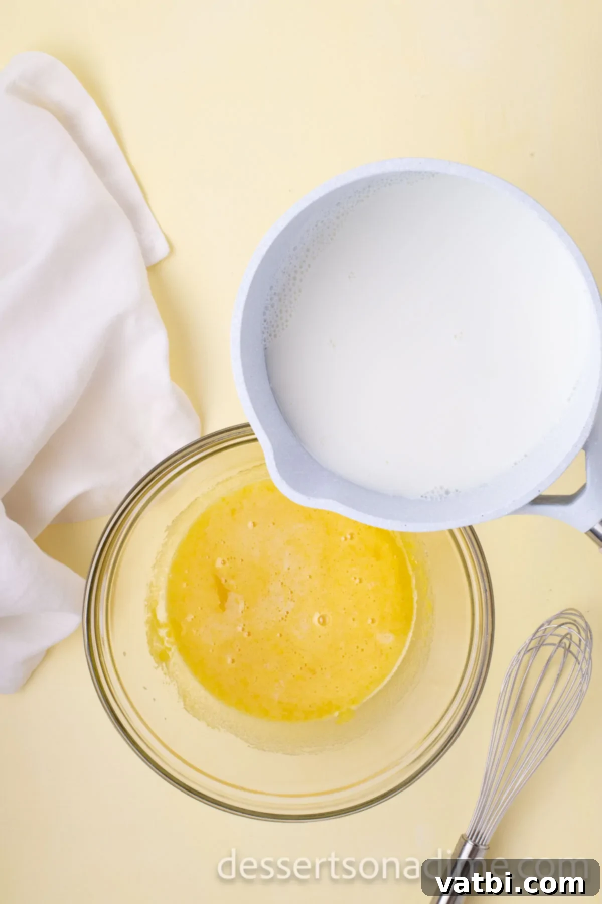 Your Own Scoop of Gelato Heaven 6 Warm milk mixture being slowly poured into the egg and sugar mixture while continuously whisking to temper the eggs.