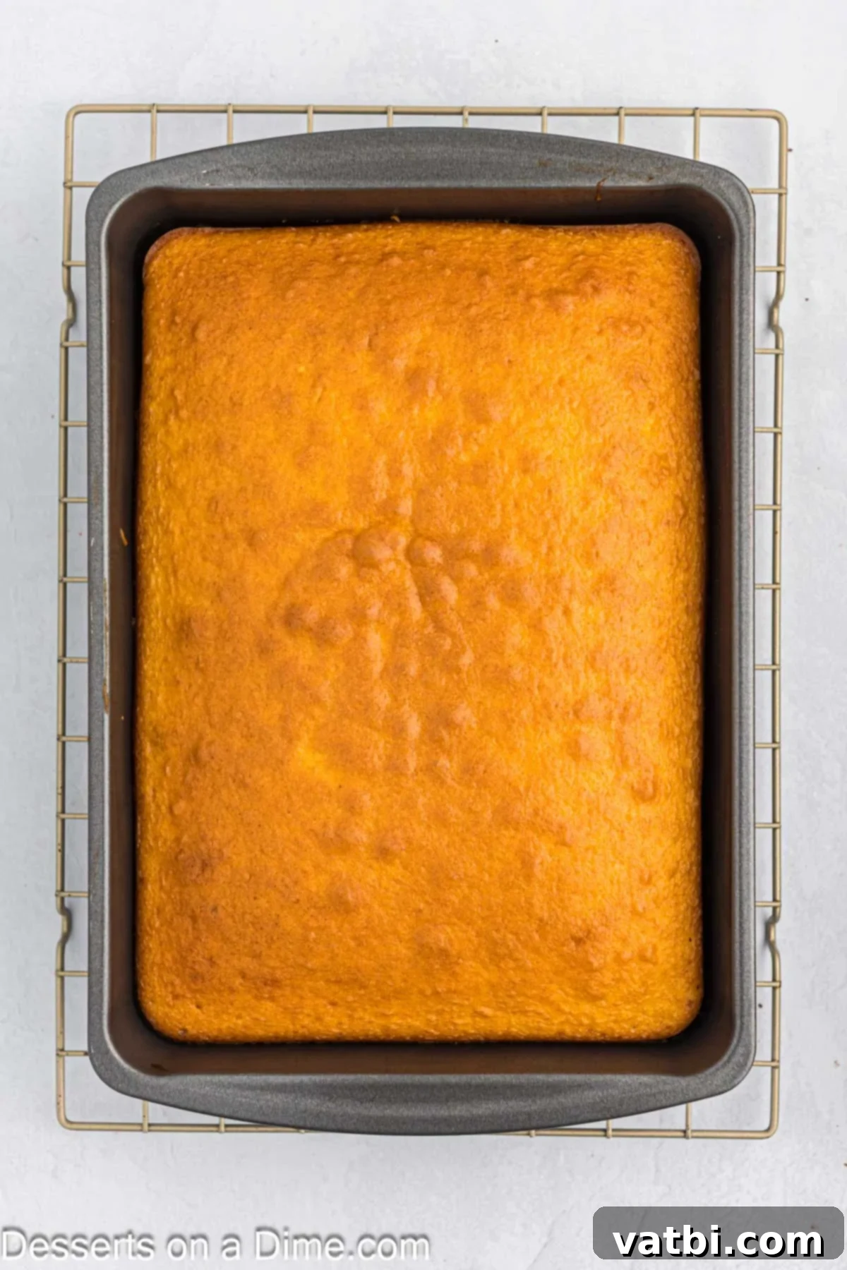 Party Punch Bowl Delight 4 A freshly baked yellow cake cooling in a 9x13 inch baking pan, ready to be cut into cubes for the punch bowl cake.