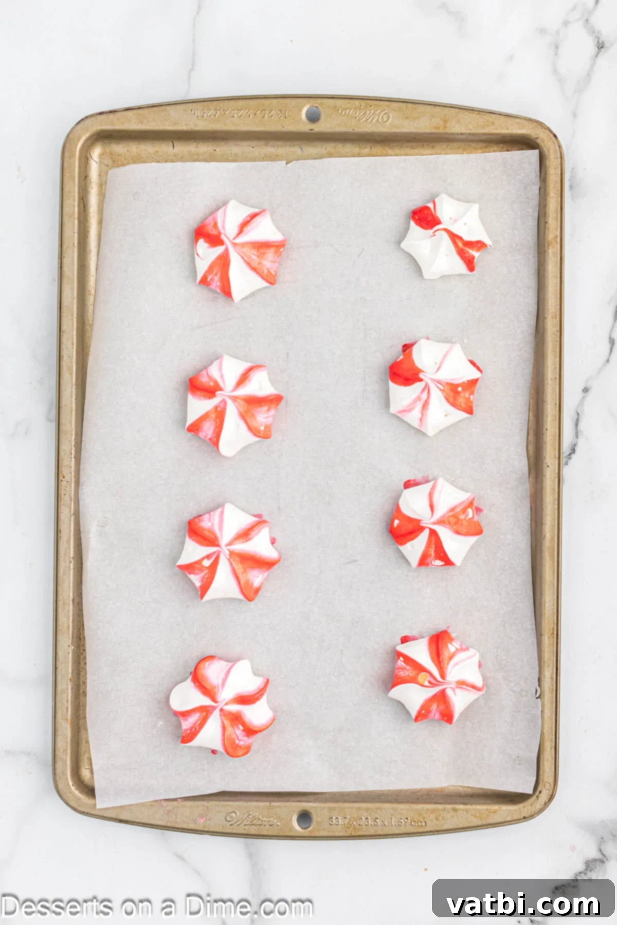 Crisp Peppermint Dream 7 Small star-shaped peppermint meringue cookies freshly piped onto a parchment-lined baking sheet.
