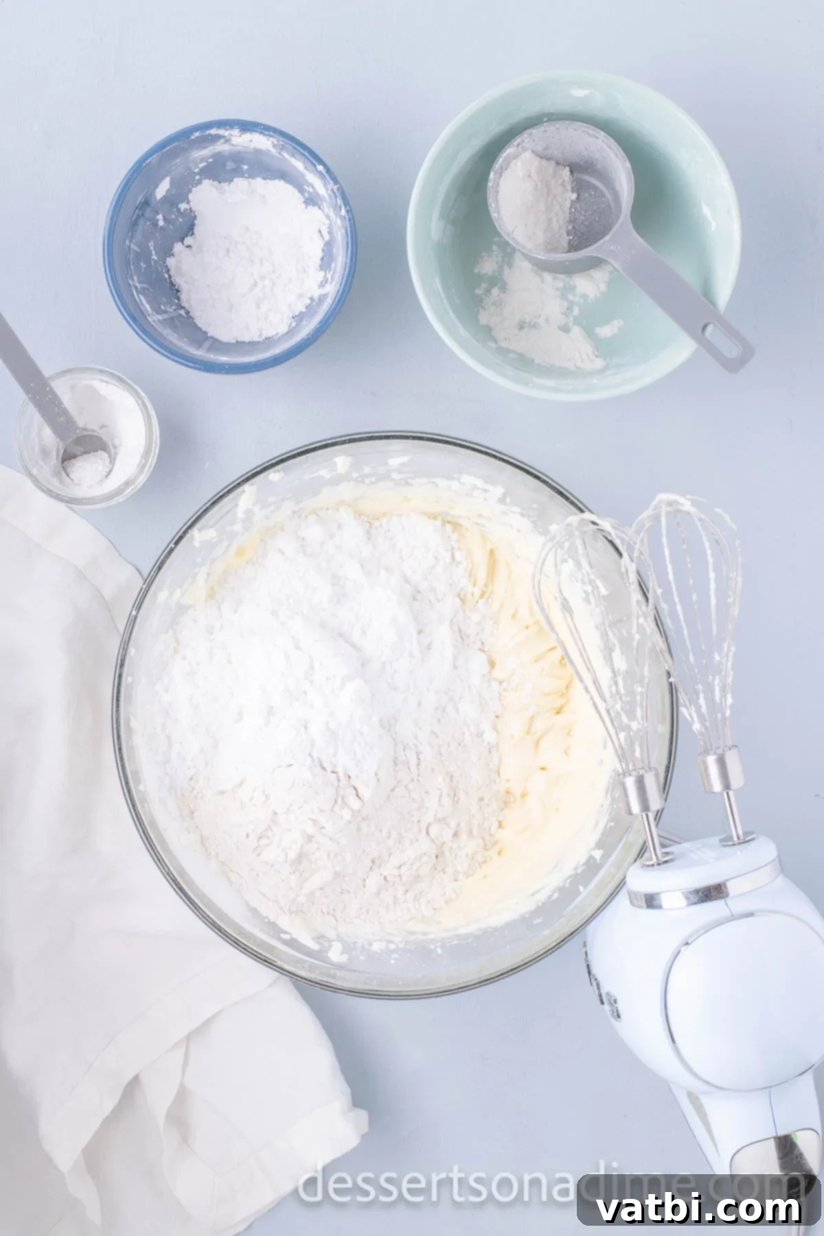 All-purpose flour gradually being added to the wet cookie dough mixture.