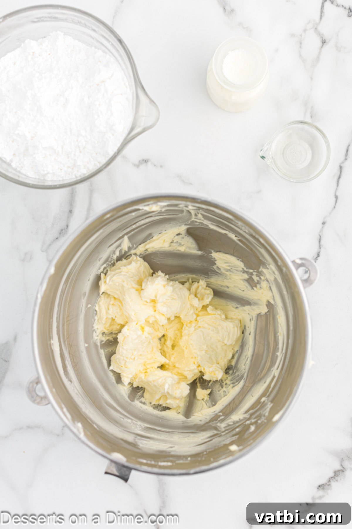 Electric mixer creaming softened unsalted butter in a large mixing bowl.