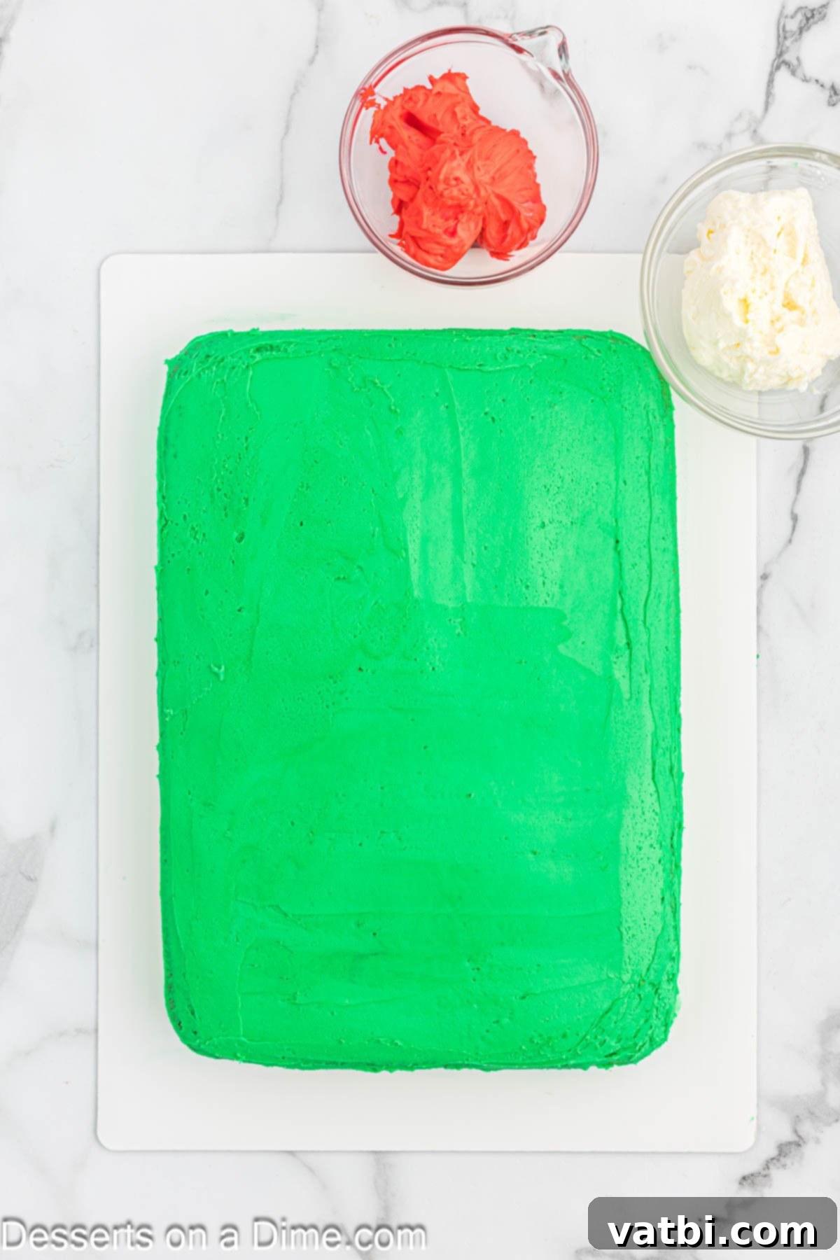 Cake completely covered with a smooth layer of green frosting on its top and sides.