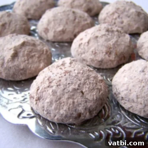 Chocolate-Filled Mexican Wedding Cookies, a decadent twist on a holiday classic, dusted with powdered sugar.