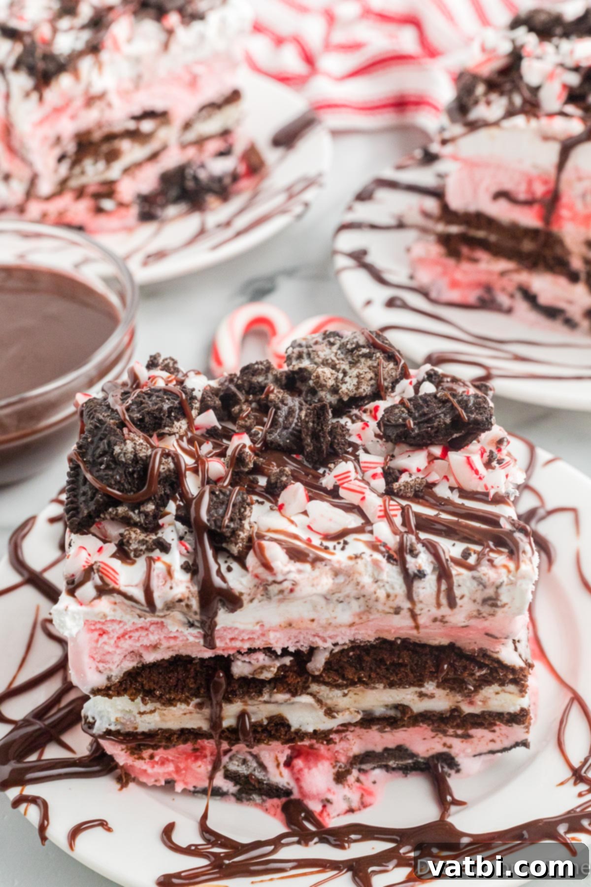 Festive Christmas Ice Cream Cake 2 Square of ice cream cake on a plate with toppings.
