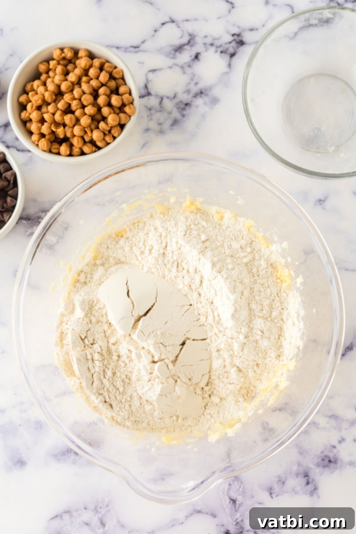 Dry ingredients, all-purpose flour and sea salt, combined in a separate bowl before being added to wet ingredients for cookie dough.