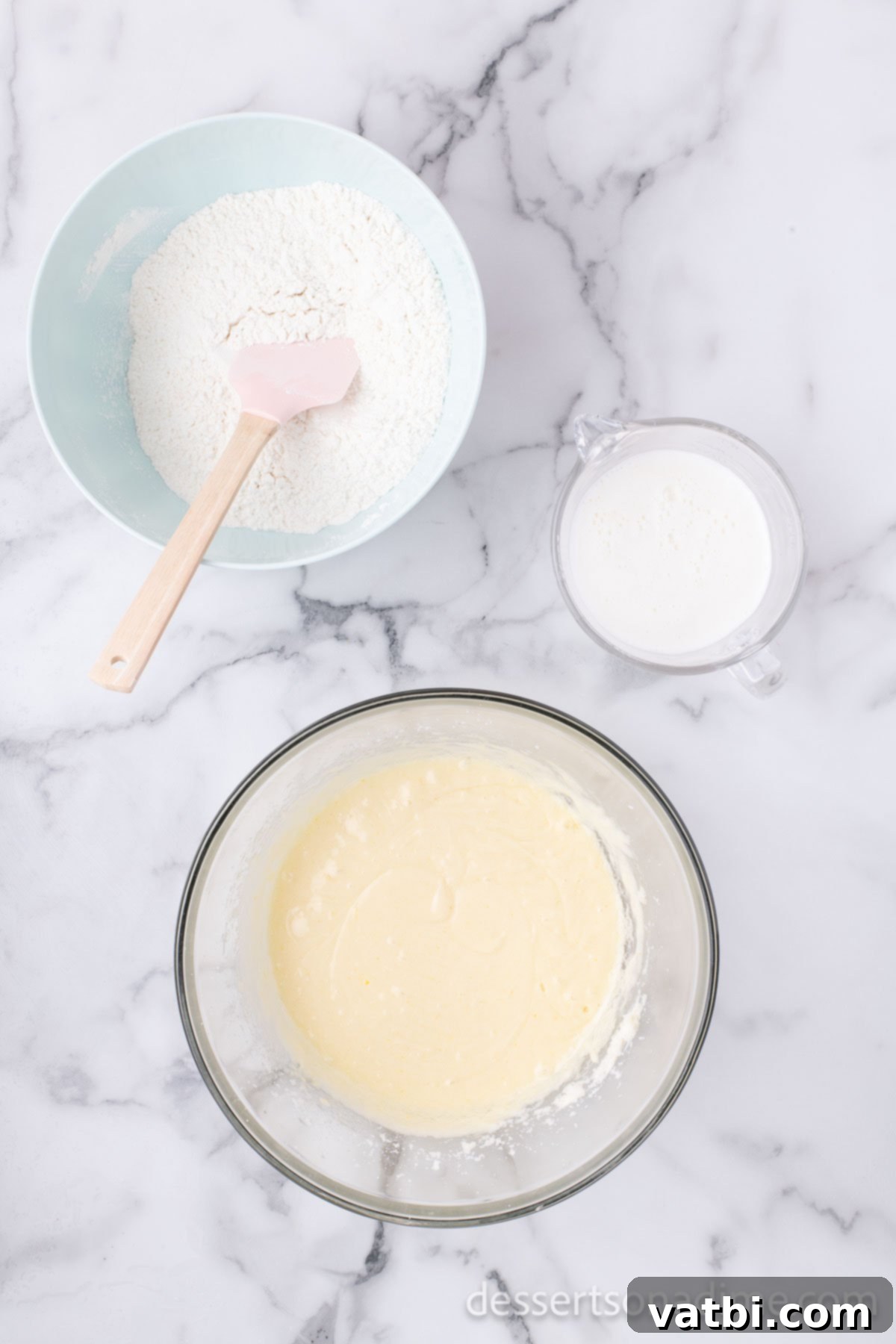 Bowl of batter with dry ingredients slowly being added to wet ingredients, alternating with milk.