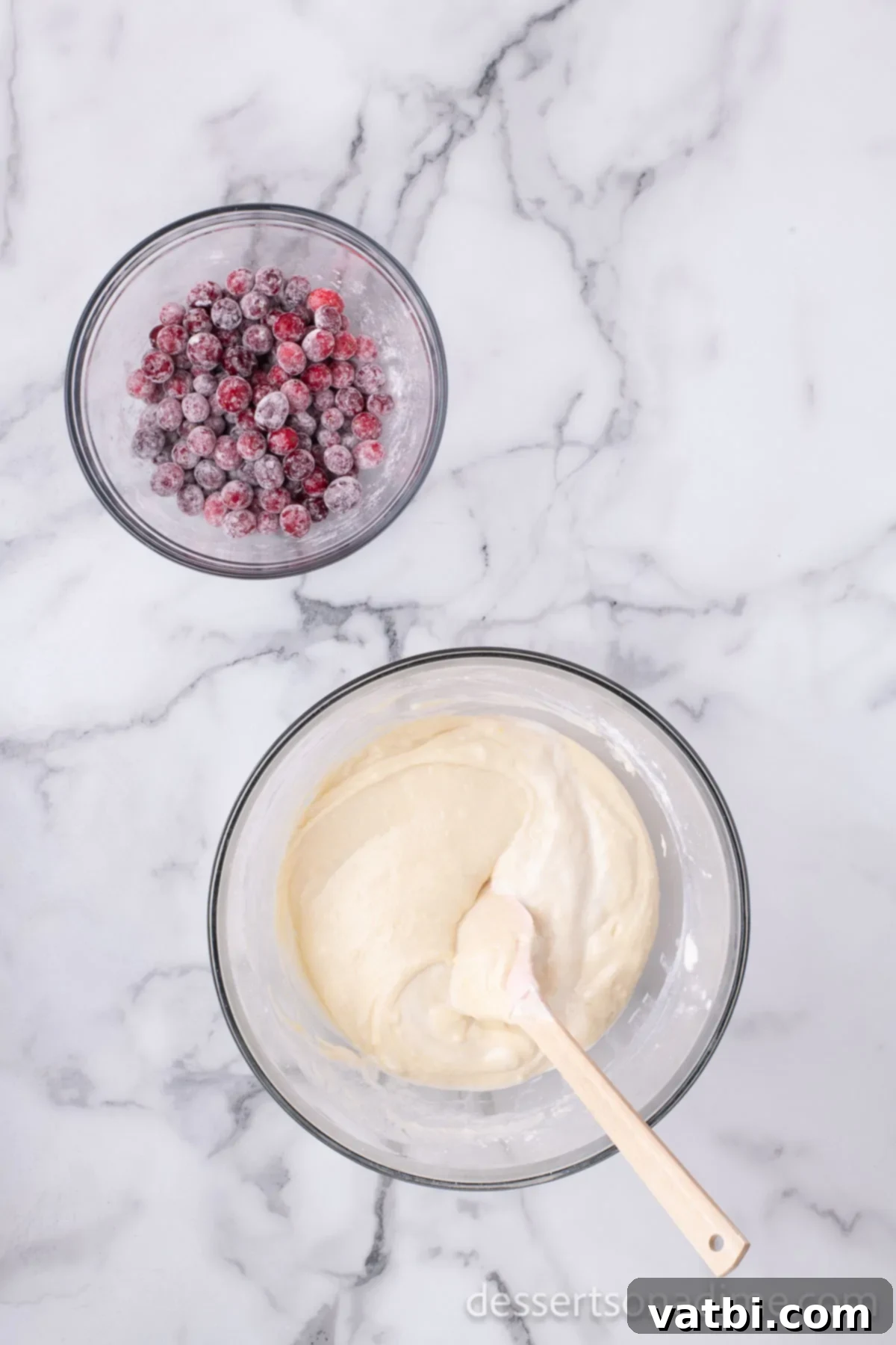 Batter combined and cranberries being gently folded in by hand.