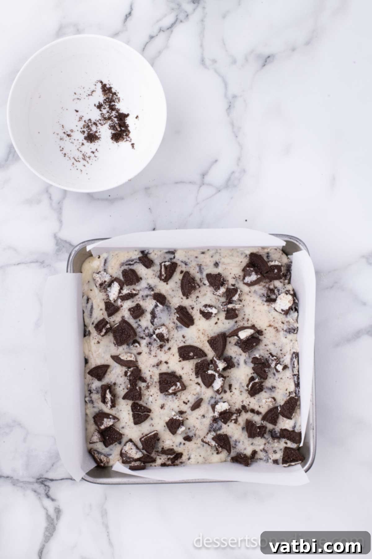 Easy 3-Ingredient Oreo Fudge 5 Fudge mixture spread into pan, topped with crushed Oreos.