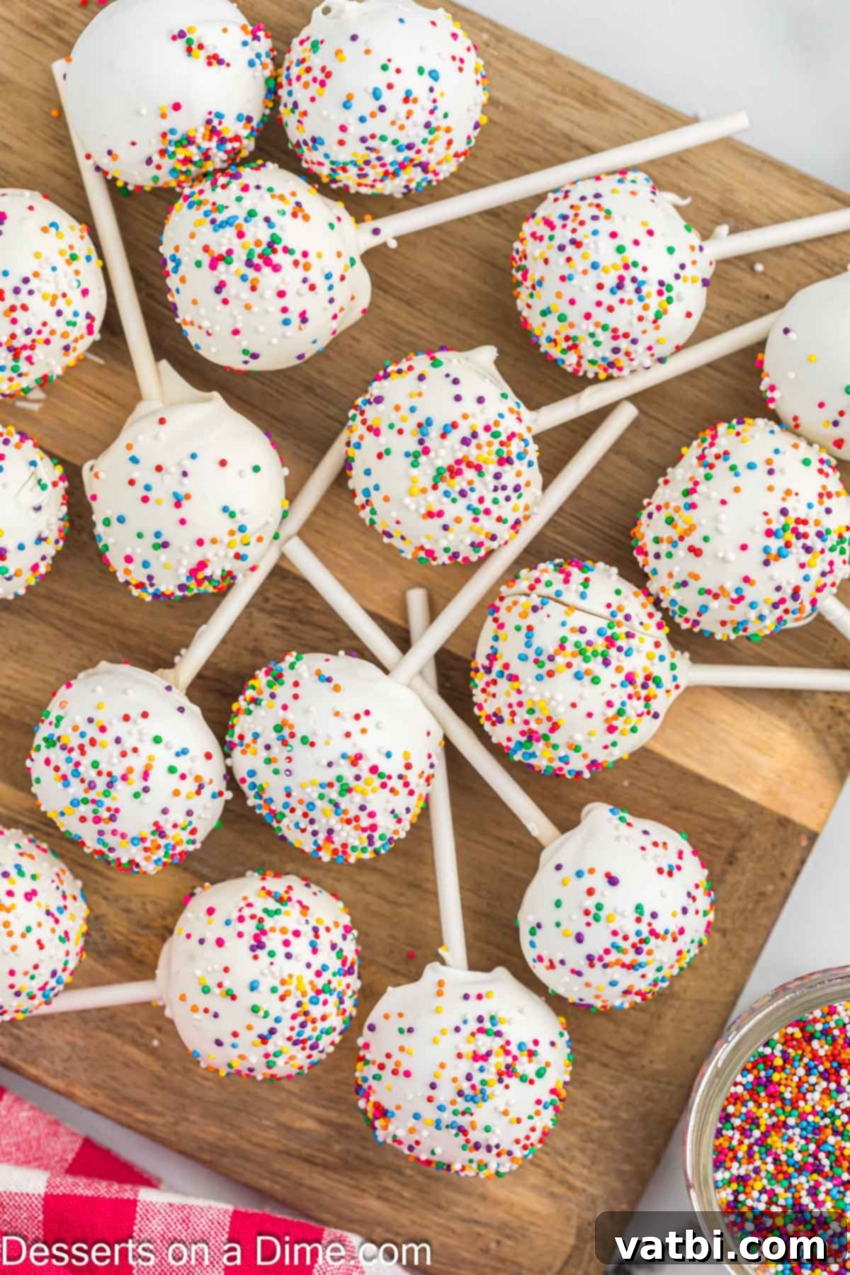 Mastering the Art of Cake Pops 12 Cake Pops on a wooden board.