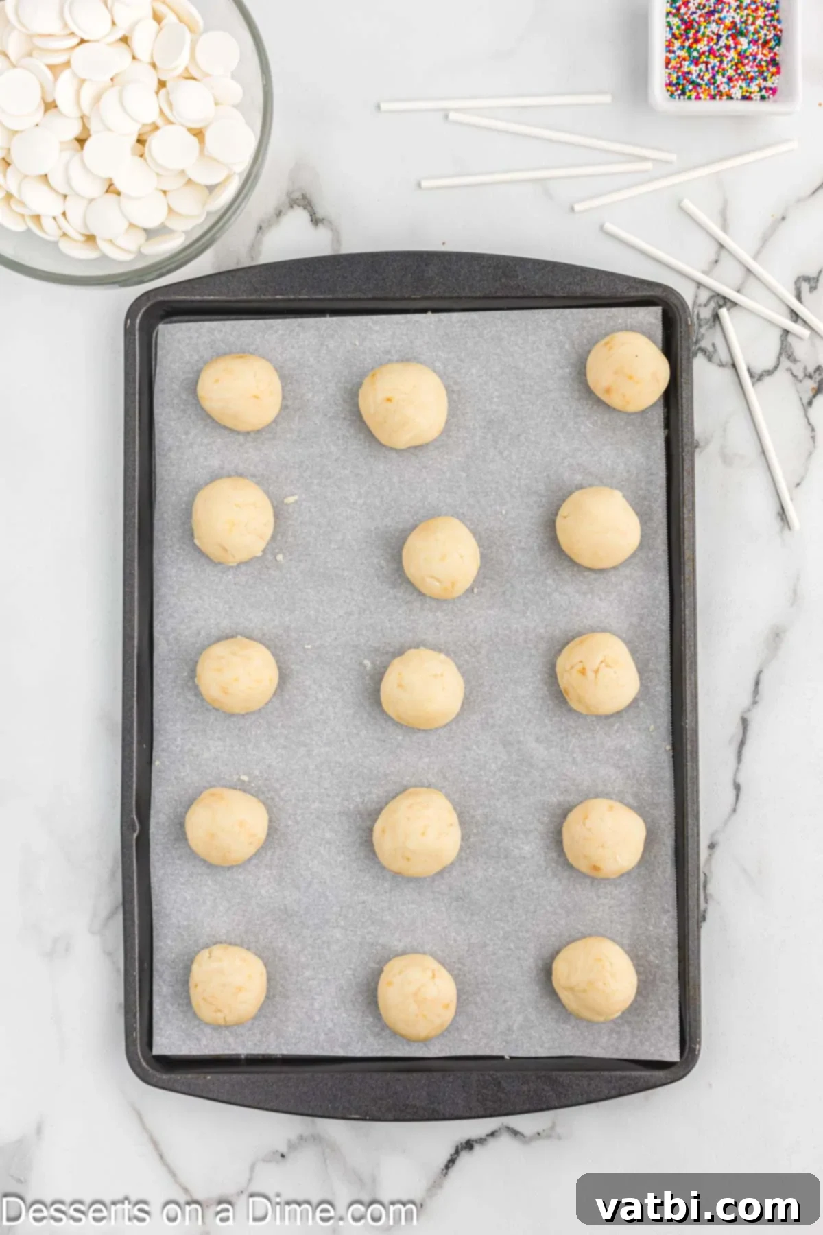 Mastering the Art of Cake Pops 6 Cake balls on a lined baking sheet.