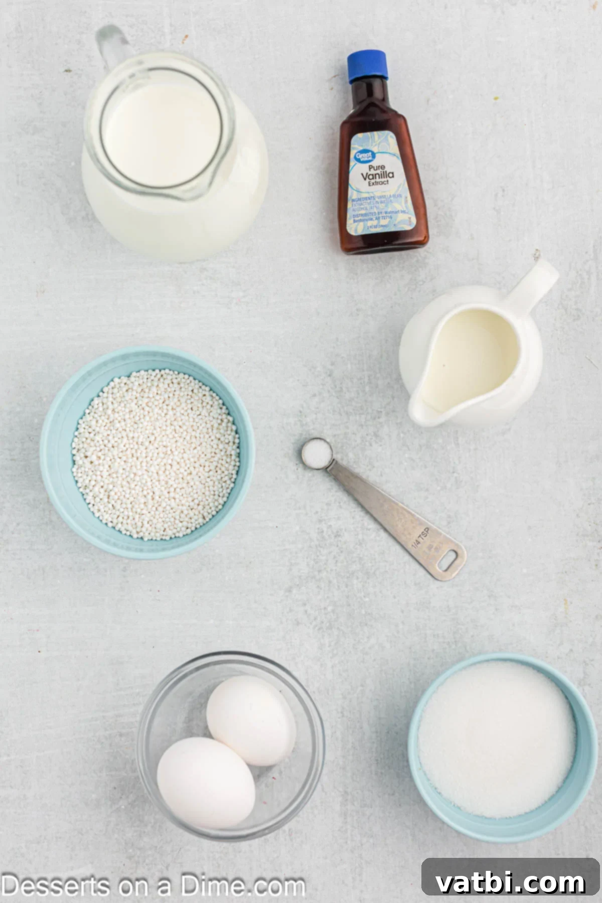 Creamy Tapioca Pudding 3 Ingredients for tapioca pudding - milk, vanilla, sugar, eggs, tapioca pearls. Laid out on a wooden surface.