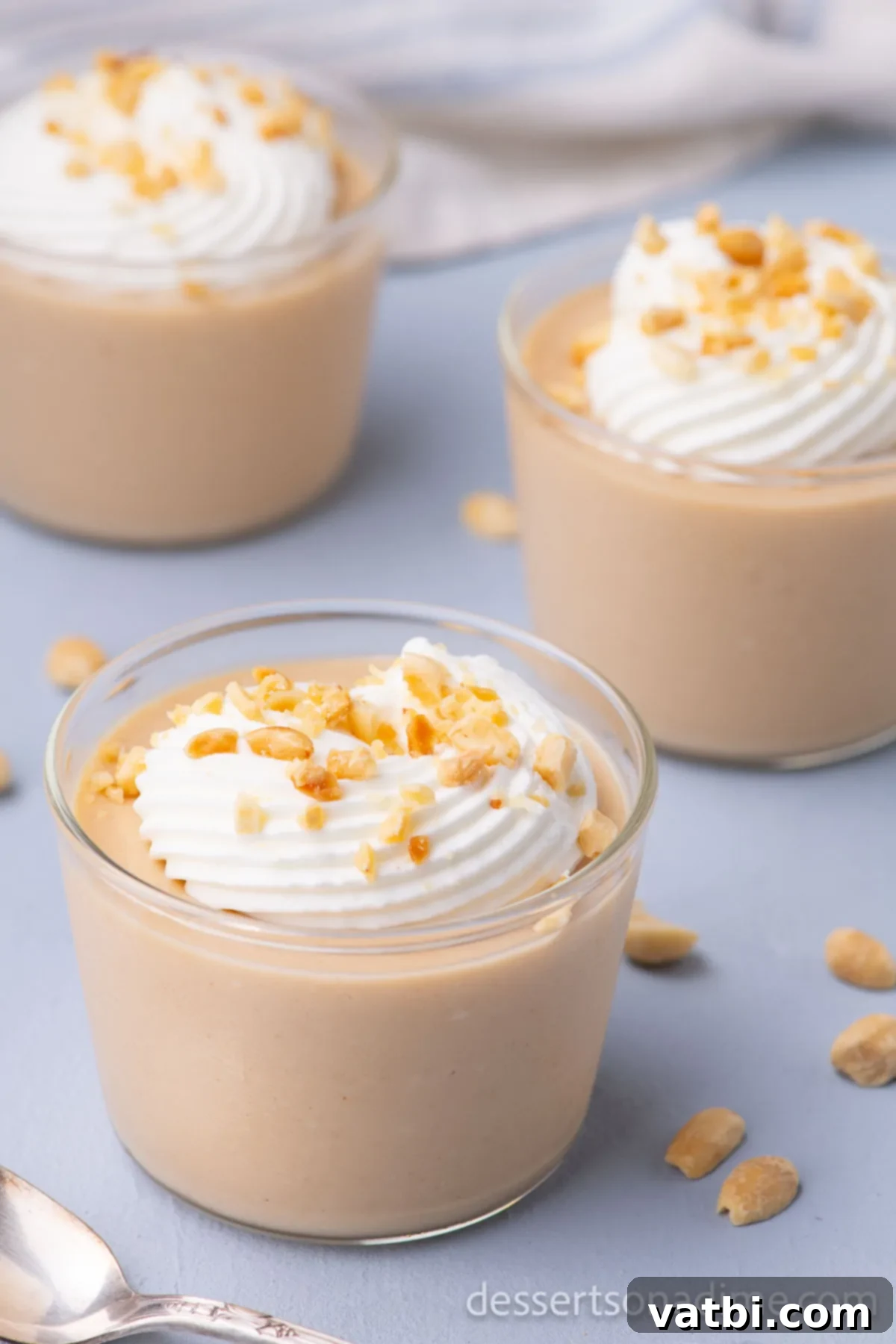 Creamy Peanut Butter Delight 11 Cups topped with whipped cream and nuts.