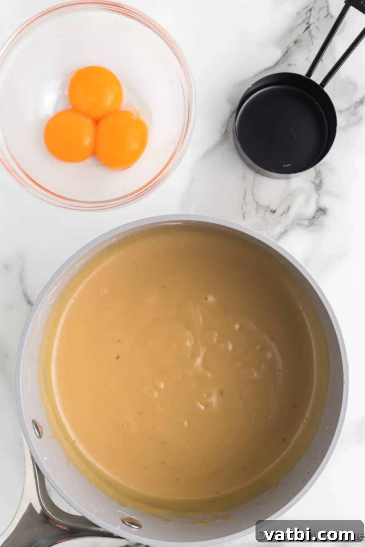 Creamy Butterscotch Bliss 7 The butterscotch pudding mixture, now combined with tempered egg yolks, being returned to the saucepan for final cooking and thickening.