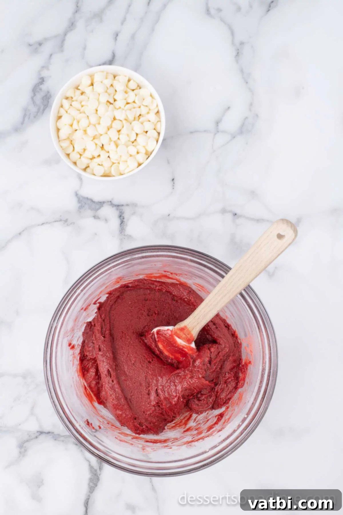 Velvet Red Brownie Bliss 3 Thick red velvet brownie batter being mixed in a bowl with a spatula.