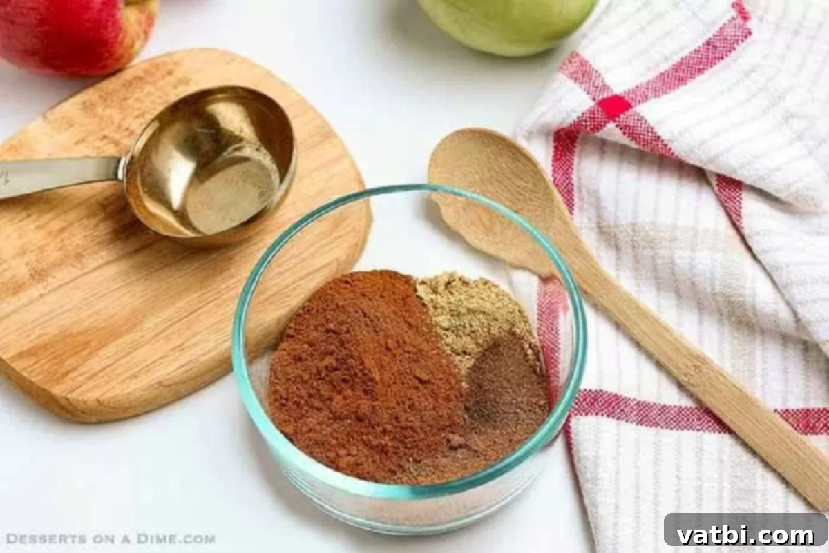 Perfect Homemade Apple Pie Spice 2 The four ground spices—cinnamon, nutmeg, allspice, and ginger—are combined in a small mixing bowl.