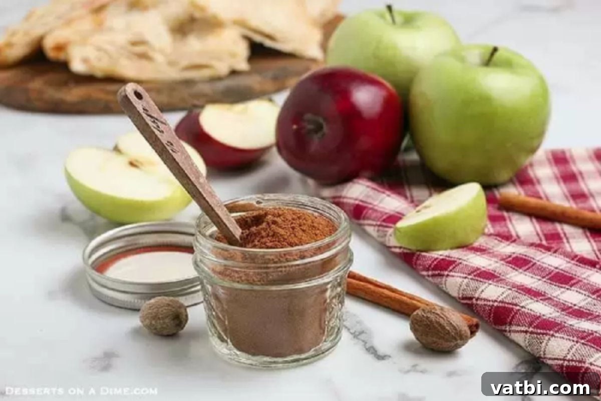 Perfect Homemade Apple Pie Spice 3 The freshly mixed apple pie spice is carefully poured from a bowl into a small glass jar, ready for storage.