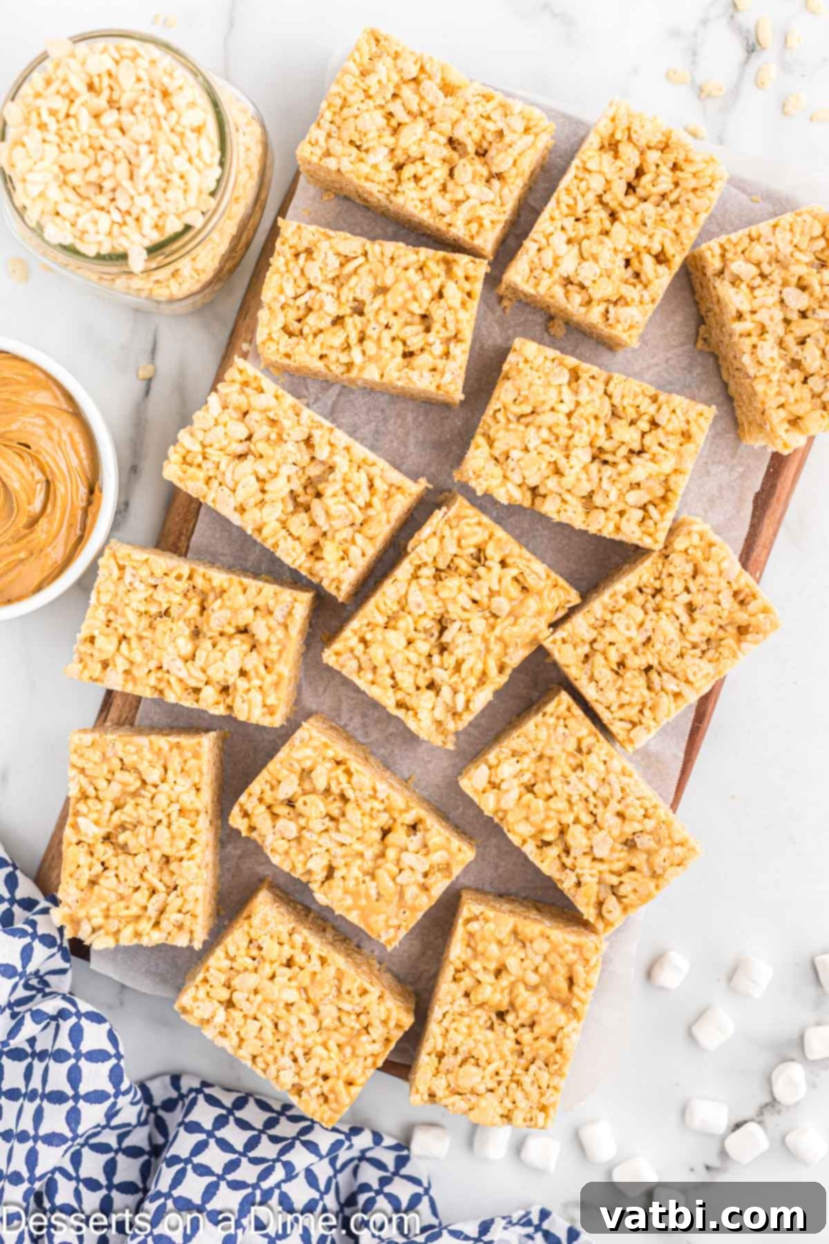 Peanut butter fans will love this easy recipe for homemade Peanut butter rice krispie treats. You only need 4 ingredients for chewy no bake rice krispie treats. This is the best dessert and so gooey and delicious with marshmallows! Try this fun recipe today. #dessertonadime #peanutbutterricekrispietreatsrecipe #ideas #microwave Close-up of cut Peanut Butter Rice Krispy Treats showing their gooey texture.