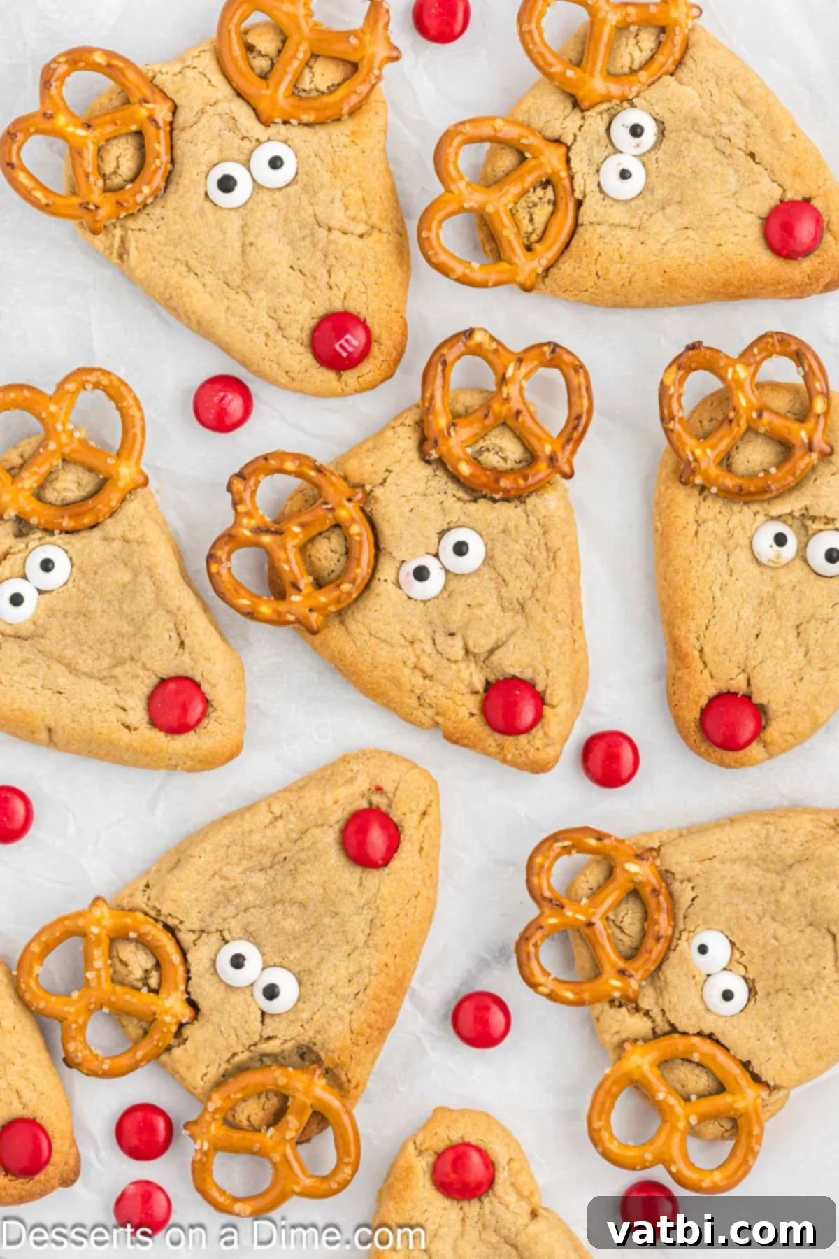 Holiday Reindeer Delights 8 Freshly baked reindeer cookies being decorated with pretzels, candy eyes, and red M&M's while still warm.