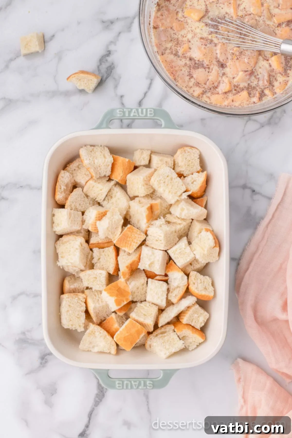 Golden Peach Bread Pudding 5 Cubed day-old bread spread evenly in a greased casserole dish, ready for the custard.