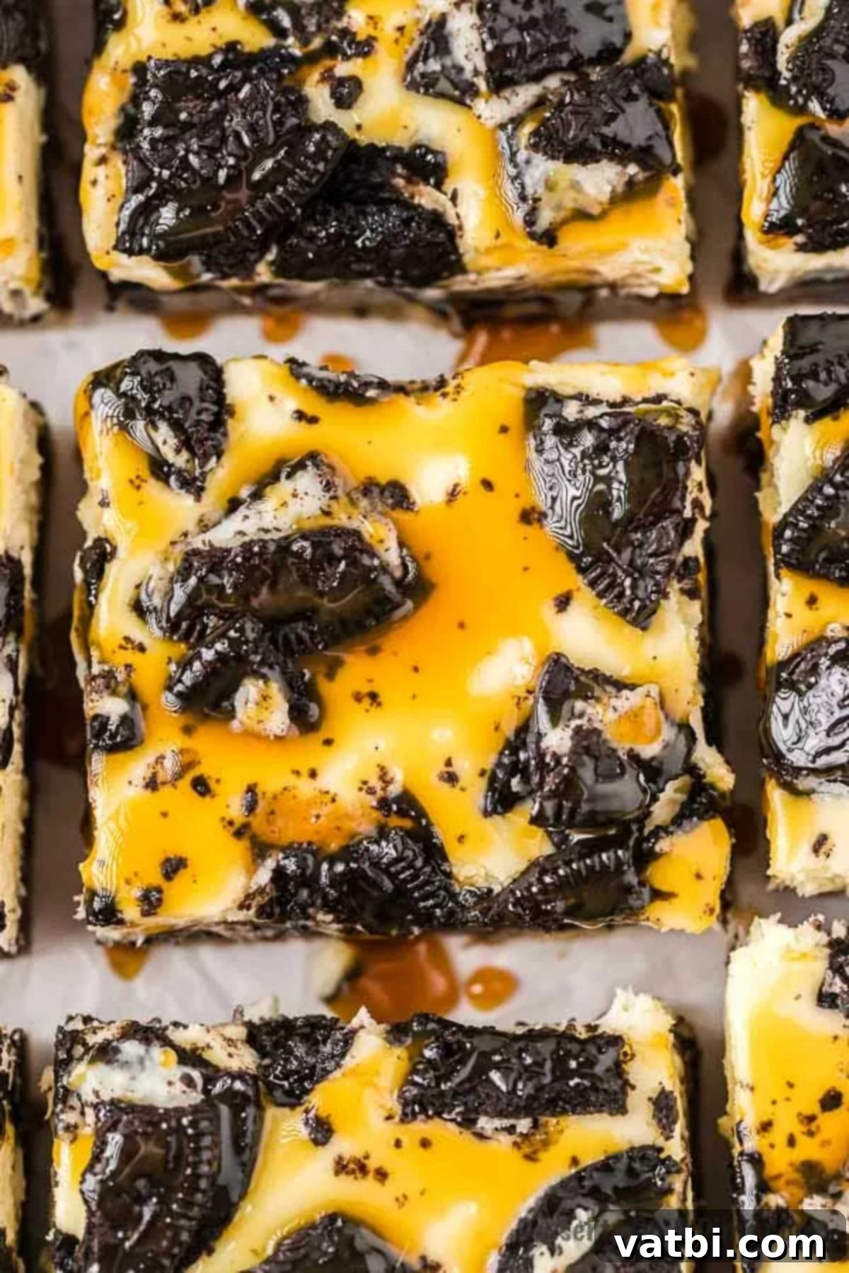 Layers of Oreo cookie with cookie dough, caramel, cheesecake and more make Slutty Cheesecake Bars so decadent. Try the best homemade treat. Learn how to make slutty cheesecake bars Recipe from scratch. #dessertonadime #sluttycheesecakebars #recipeeasy Decadent Slutty Oreo Cheesecake Bars cut into perfect squares and stacked, showcasing layers of cookie dough, Oreos, cheesecake, and caramel drizzle.