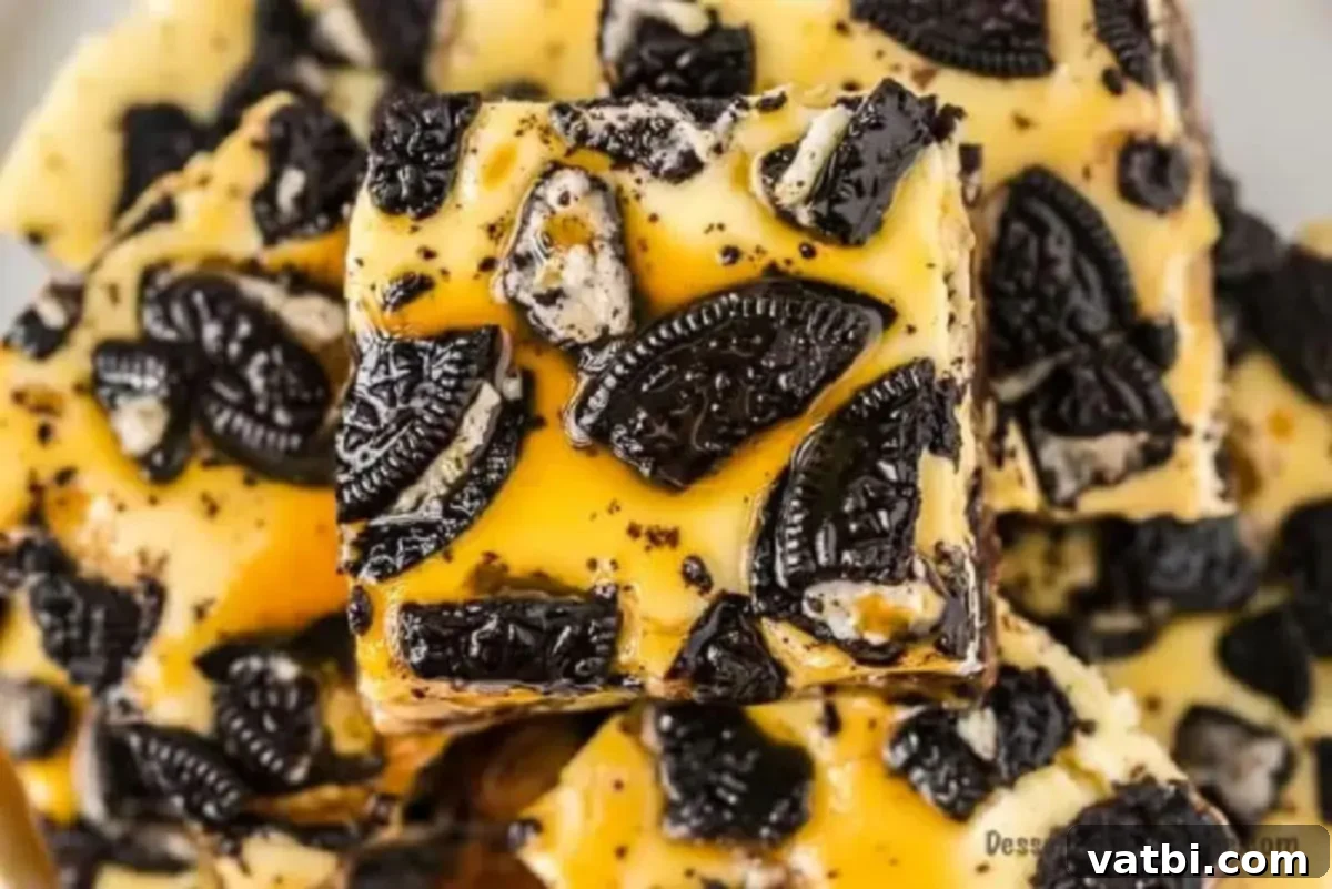 Decadent Loaded Cheesecake Bars 6 Close-up of baked Slutty Cheesecake Bars, still in the pan, showing the rich, set cheesecake layer with Oreo pieces on top.