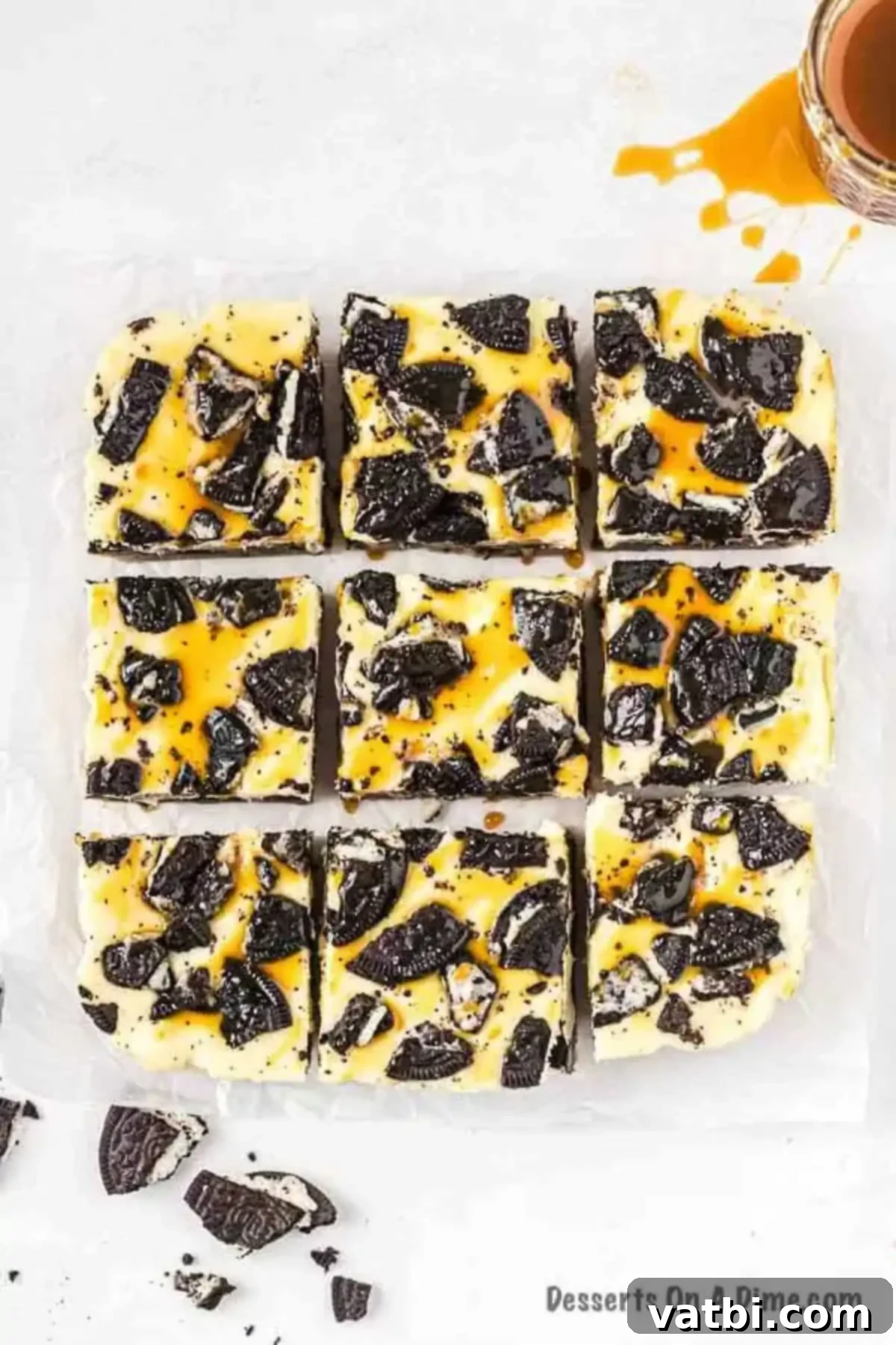 Layers of Oreo cookie with cookie dough, caramel, cheesecake and more make Slutty Cheesecake Bars so decadent. Try the best homemade treat. Learn how to make slutty cheesecake bars Recipe from scratch. #dessertonadime #sluttycheesecakebars #recipeeasy Close-up of freshly cut Slutty Oreo Cheesecake Bars, showcasing distinct layers of cookie dough, whole Oreos, creamy cheesecake, and a sprinkle of crushed Oreos on top.