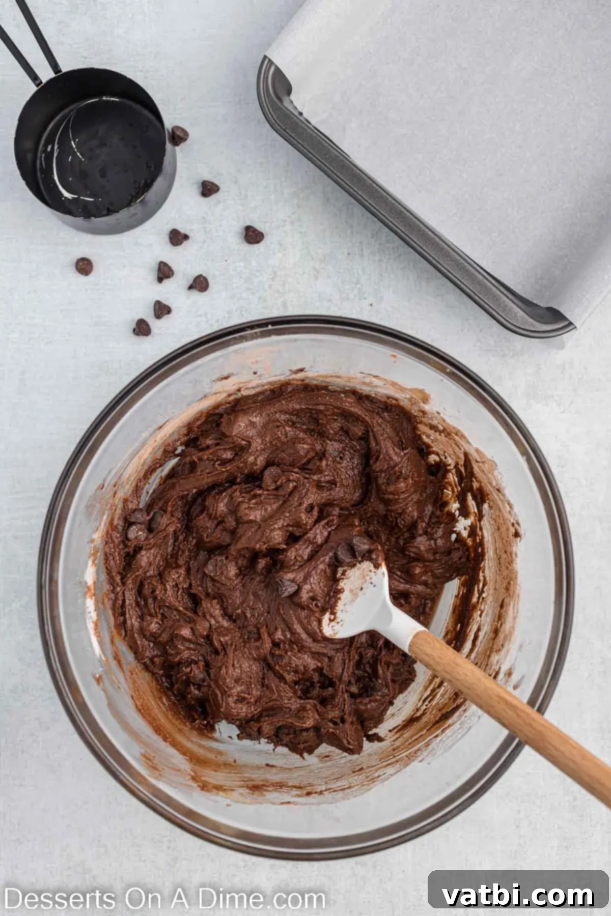 Decadent Oreo Brownies 4 The dry ingredients, including cocoa powder, flour, salt, and baking powder, are carefully added to the wet butter and sugar mixture in a bowl.