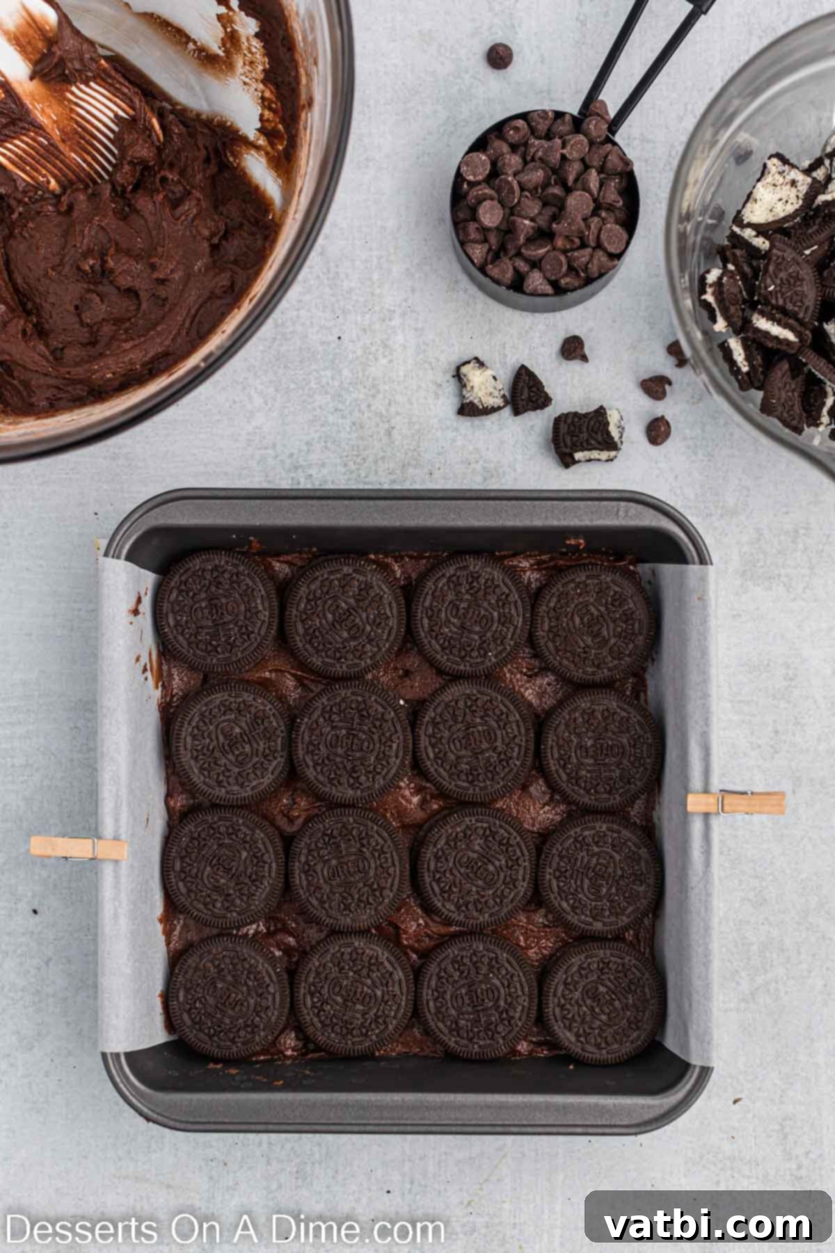 Decadent Oreo Brownies 6 A grid of whole Oreo cookies is neatly placed on top of the first layer of brownie batter in the baking pan, creating a delicious cookie-filled center.
