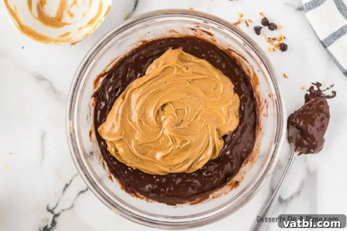Mixing bowl with melted chocolate and creamy peanut butter for fudge.