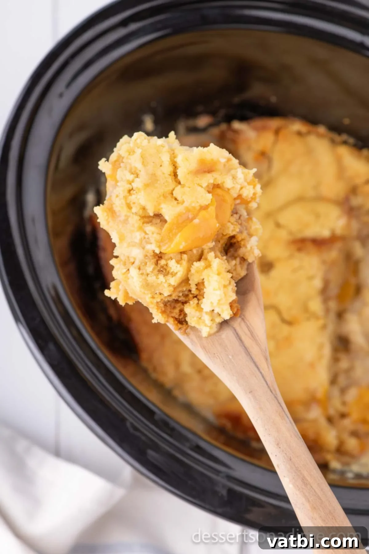 Effortless Slow Cooker Peach Delight 8 Dump Cake being served.