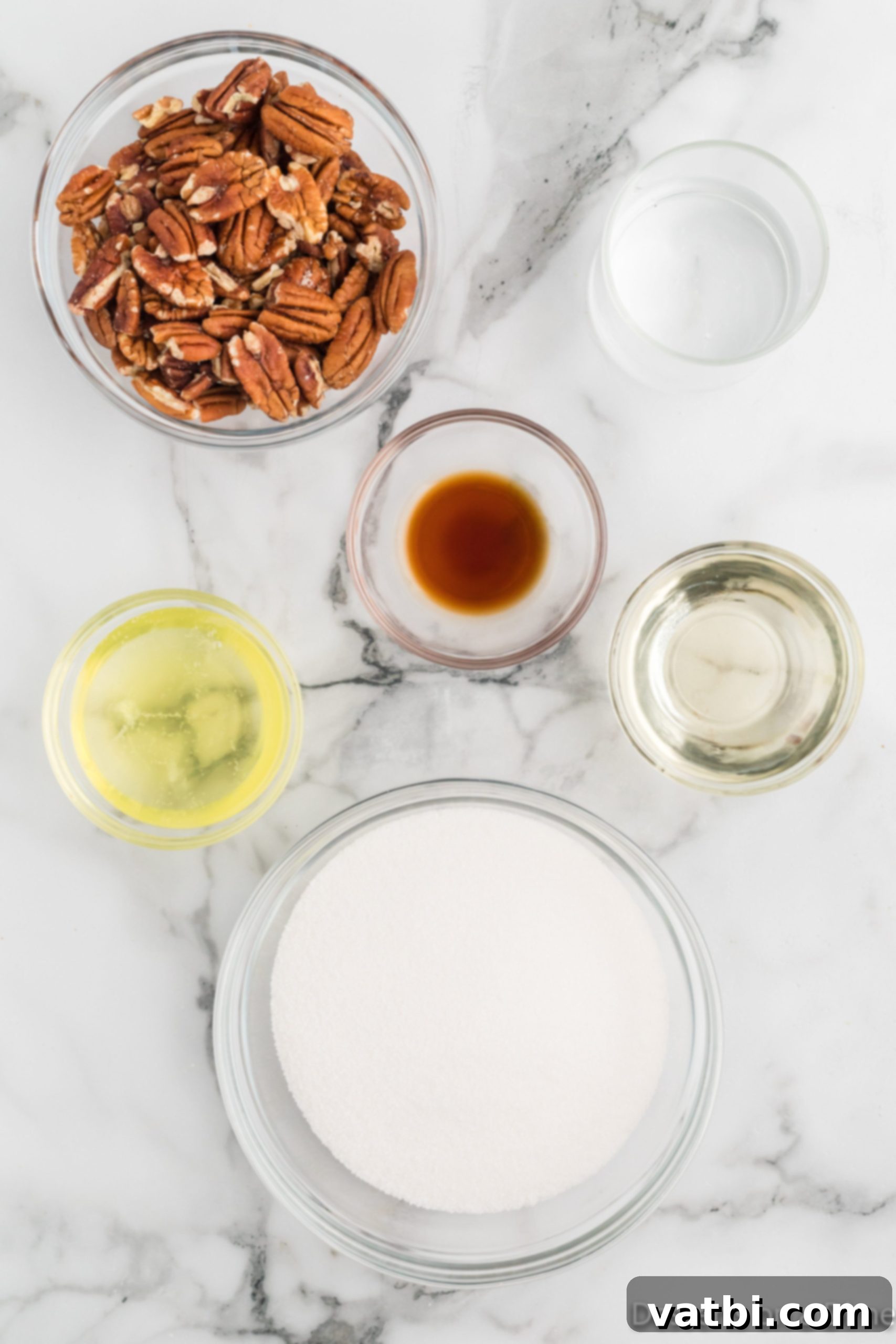 Grandma's Divinity Candy Recipe 3 Ingredients for Divinity Candy: nuts, vanilla extract, egg whites, water, and corn syrup, laid out on a clean surface.