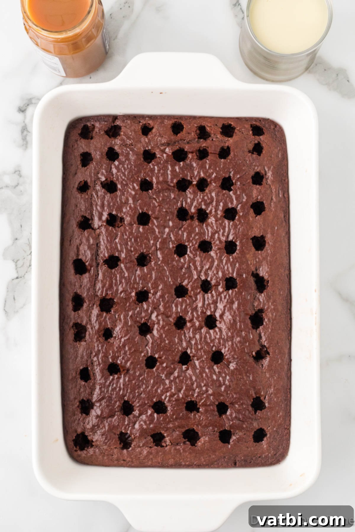 Liquid Gold Chocolate Poke Cake 5 Holes poked all over cake.