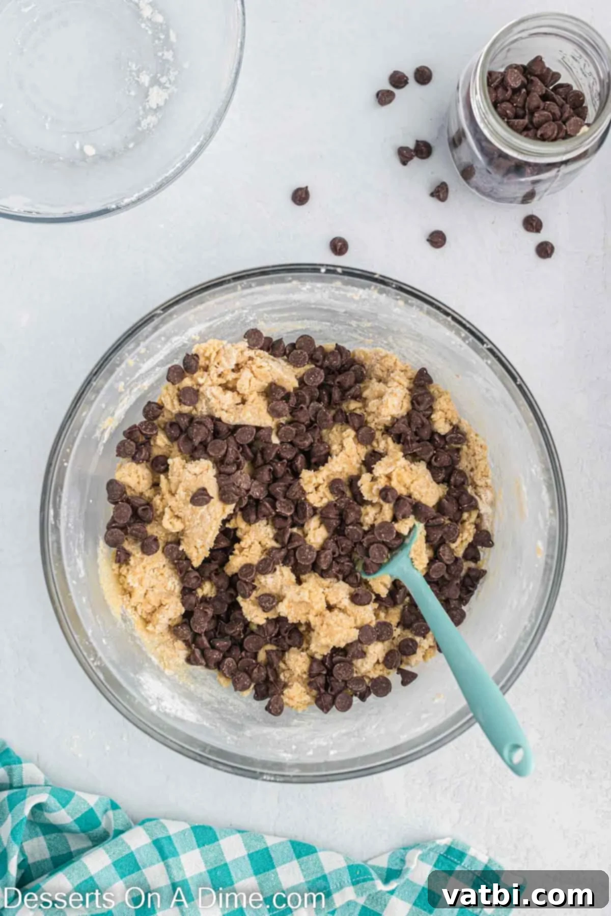 Effortless Chocolate Chip Perfection 3 Semi-sweet chocolate chips gently folded into the cookie dough batter in a mixing bowl