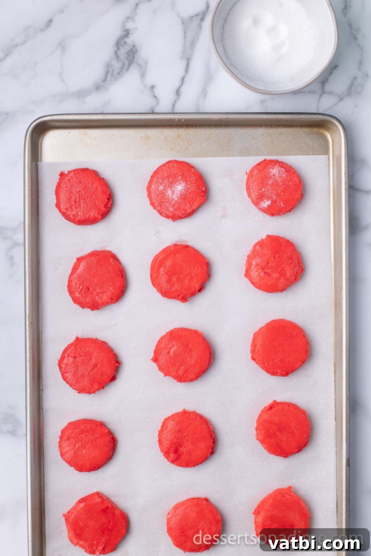 Dipped Peppermint Chocolate Delights 9 Cookies flattened on baking sheet and topped with sugar. Cookies ready for baking.