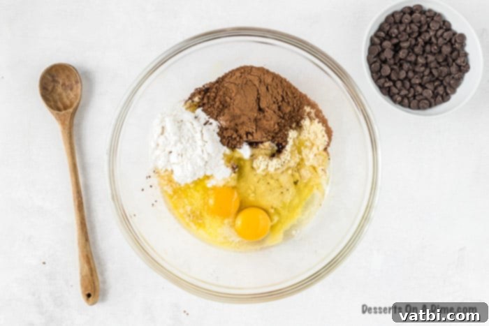 Decadent Keto Brownies 2 Mixing bowl with brownie mixture being combined by hand.