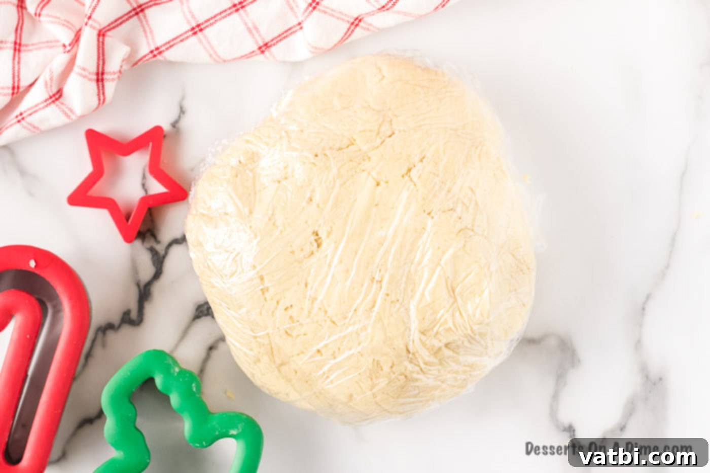 Festive Christmas Cut-Out Sugar Cookies 3 Cookie dough wrapped in plastic wrap, ready for chilling.
