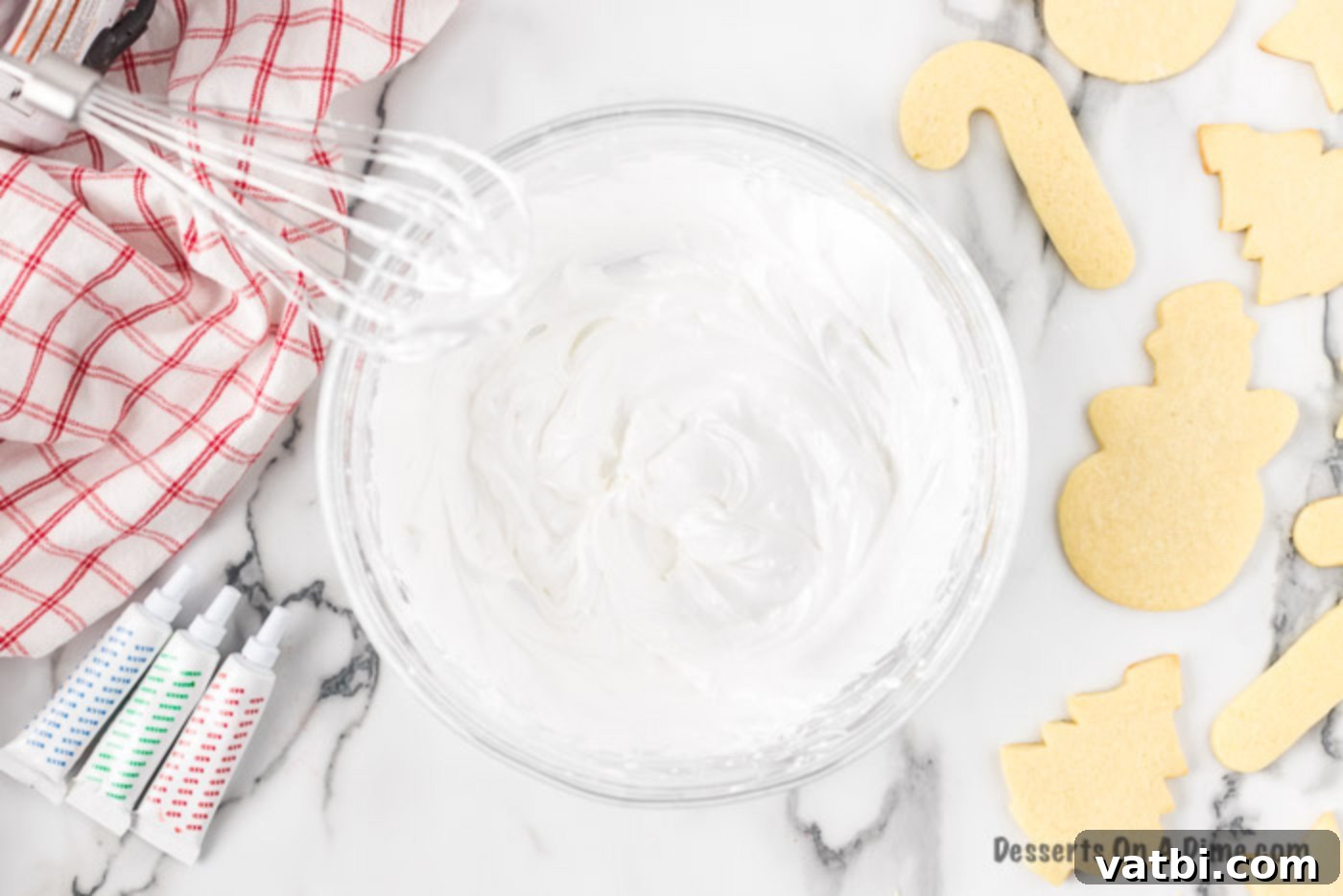 Festive Christmas Cut-Out Sugar Cookies 7 Bowl with royal icing and a beater, showing the smooth consistency.