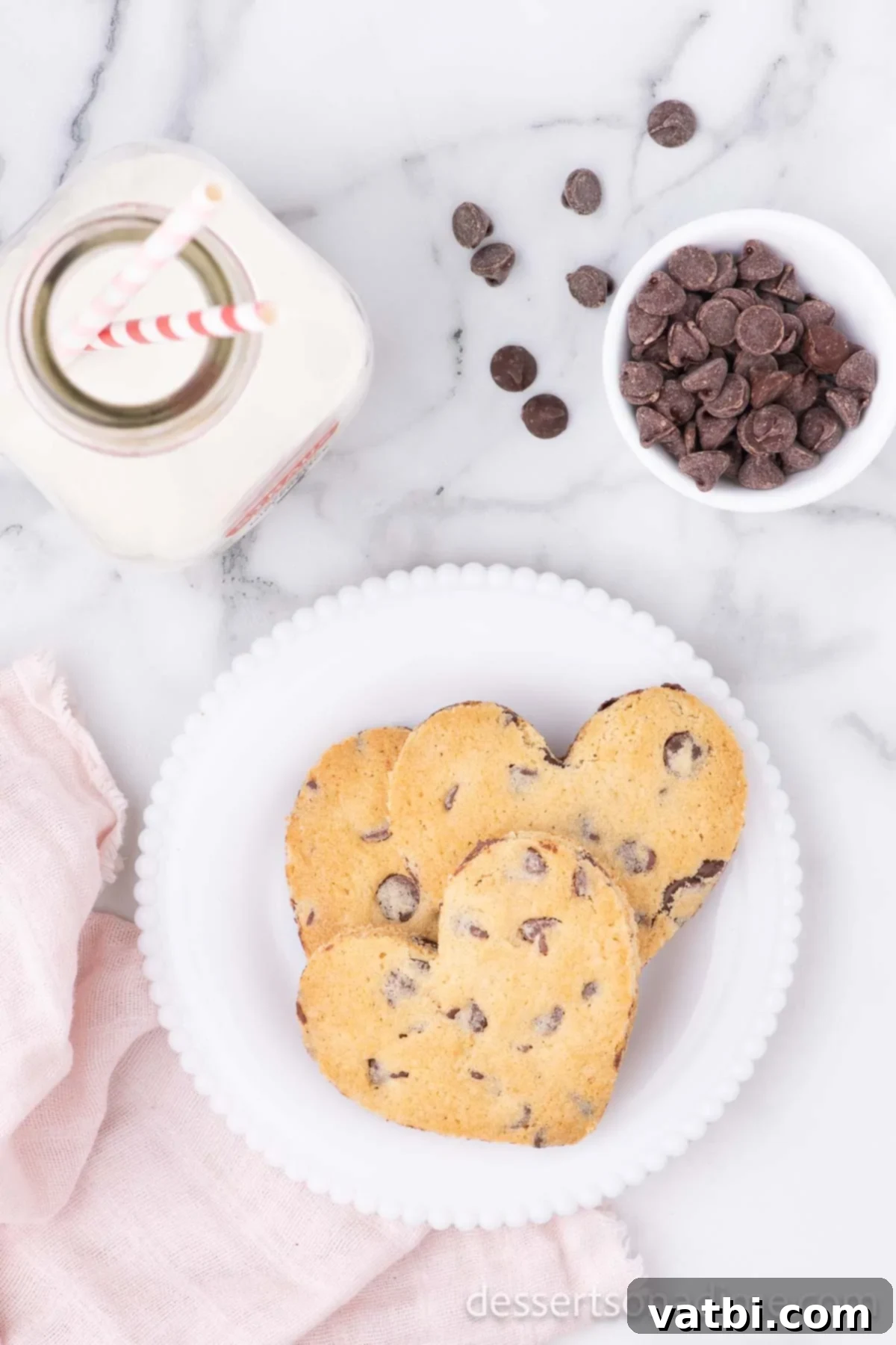 Love-Filled Chocolate Chip Hearts 11 A plate of Heart Shaped Chocolate Chip Cookies with a glass of milk.