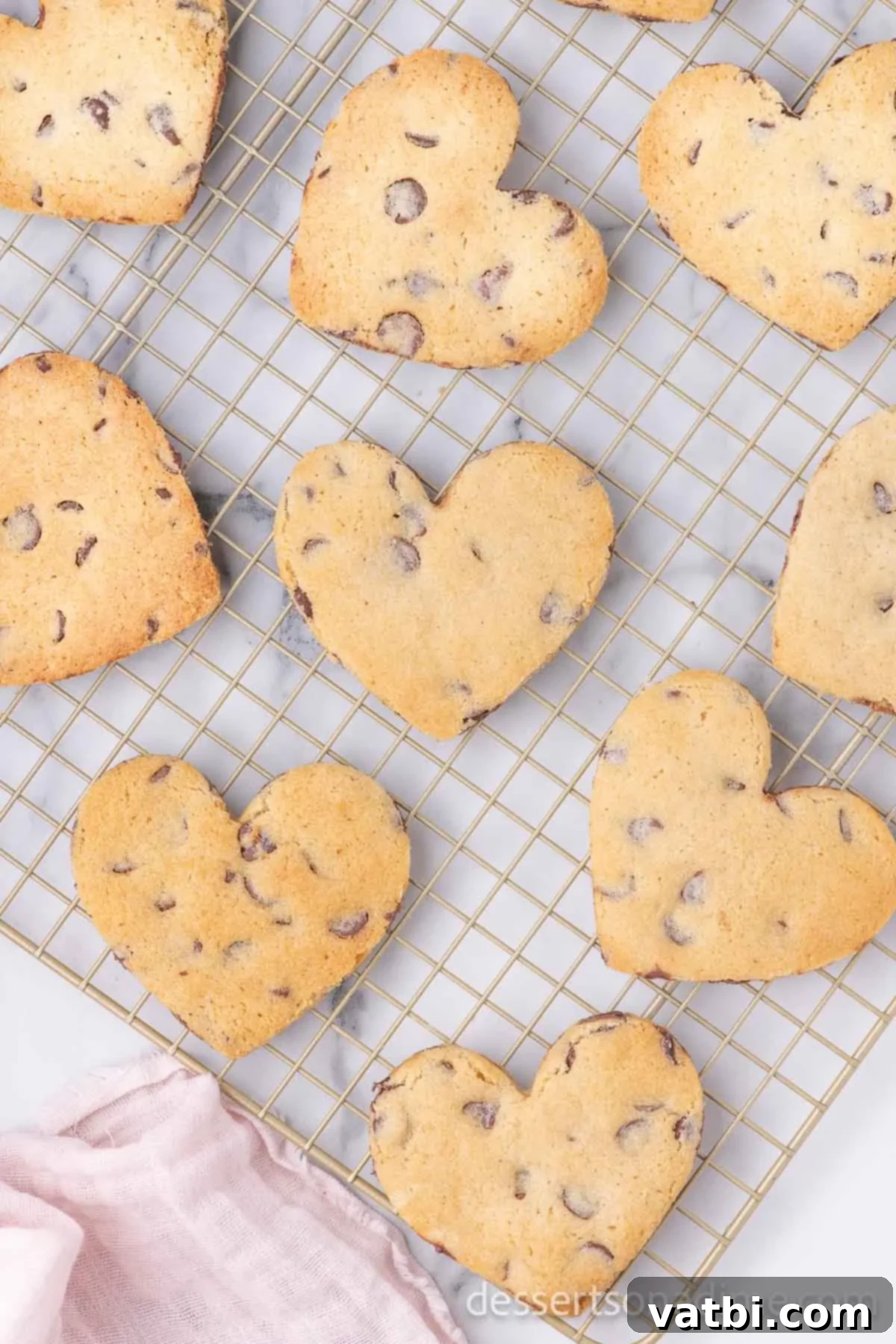 Love-Filled Chocolate Chip Hearts 9 Freshly baked Heart Shaped Chocolate Chip Cookies cooling on a wire rack.