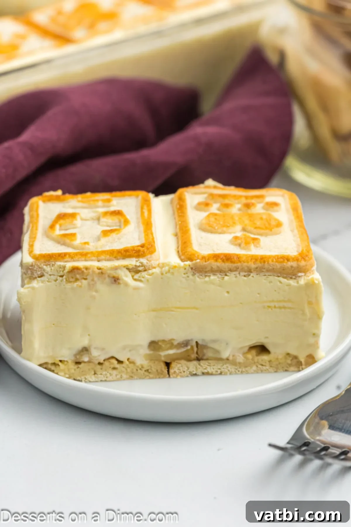 Serving of banana pudding on plate, showcasing the creamy layers and cookie topping.