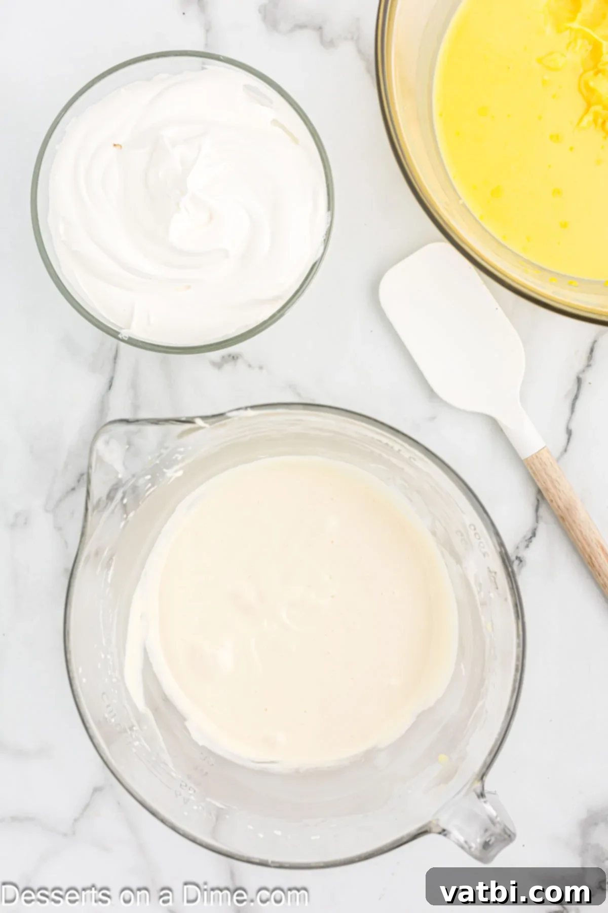 Softened cream cheese and sweetened condensed milk being beaten together in a separate bowl.