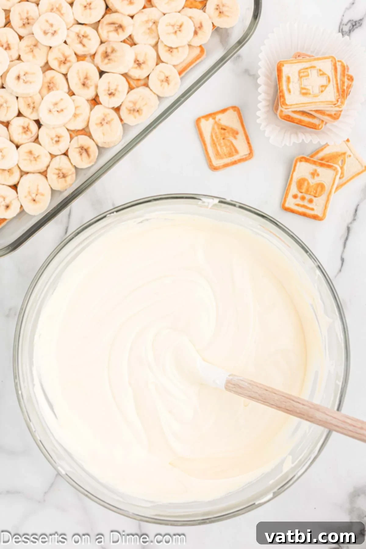 The cream cheese and whipped topping mixture being combined with the thickened pudding.